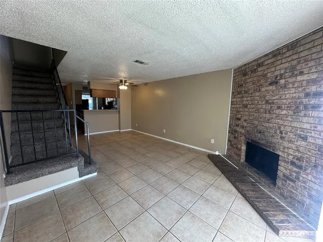 a view of empty room with stairs and fireplace