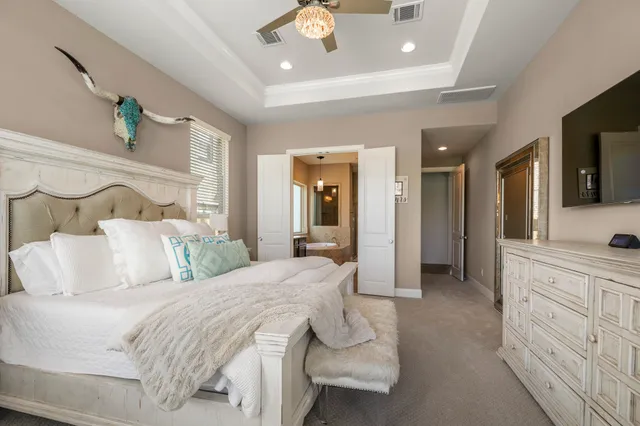 a spacious bedroom with a large bed and ceiling fan