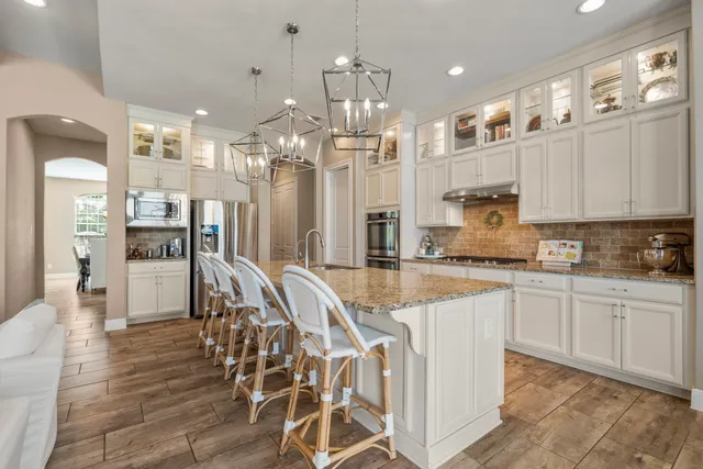 a large kitchen with granite countertop a large counter top appliances and cabinets