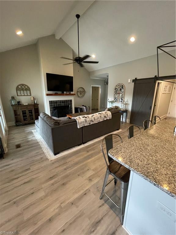 8805 Colgate Road Stokesdale, NC 27357 - Photo 29 of 34 Great room with open floor plan, gas logs, vinyl plank flooring. Great for entertaining and opens to the covered back deck that looks over the large fenced in back yard with garden boxes and a cute chicken house.