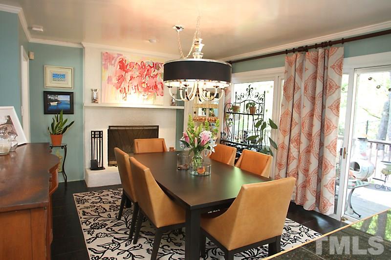 809 Currituck Drive Raleigh, NC 27609 - Photo 4 of 14 a dining room with furniture a fireplace and wooden floor