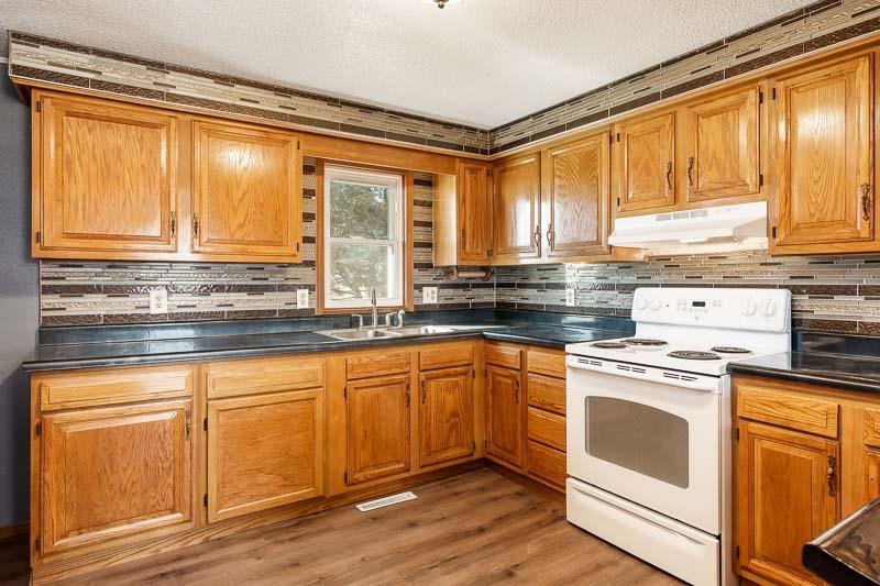4422 North Union Road Forreston, IL 61030 - Photo 41 of 60 a kitchen with stainless steel appliances granite countertop a stove a sink and a microwave