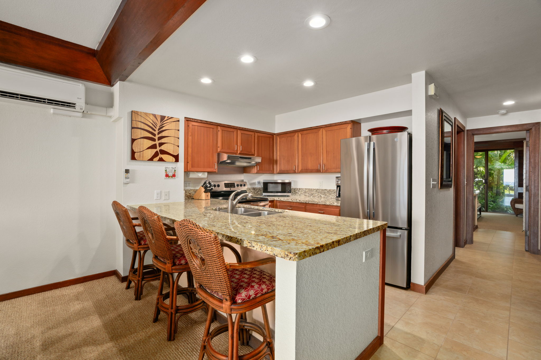 2221 Kapili Road, Unit 25 Koloa, HI 96756 - Photo 3 of 6 a kitchen with stainless steel appliances granite countertop sink refrigerator dining table and chairs