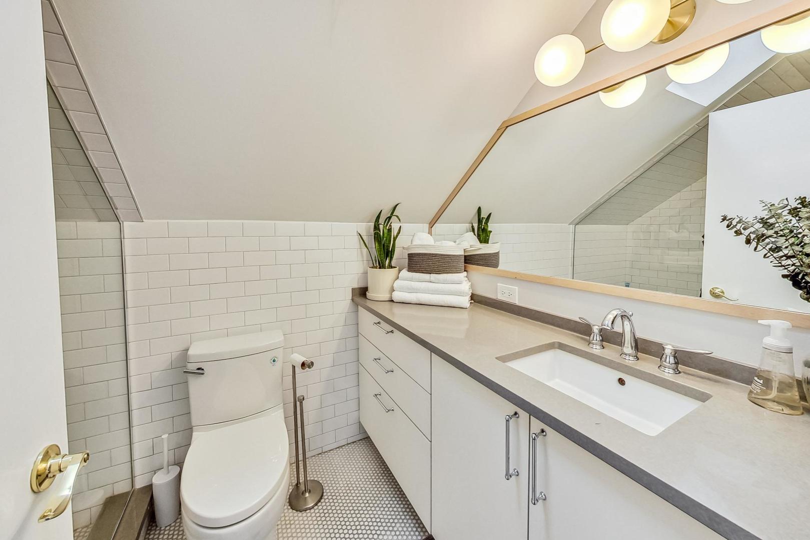 48 Williamsburg Road Evanston, IL 60203 - Photo 19 of 42 a bathroom with a double vanity sink toilet and a mirror