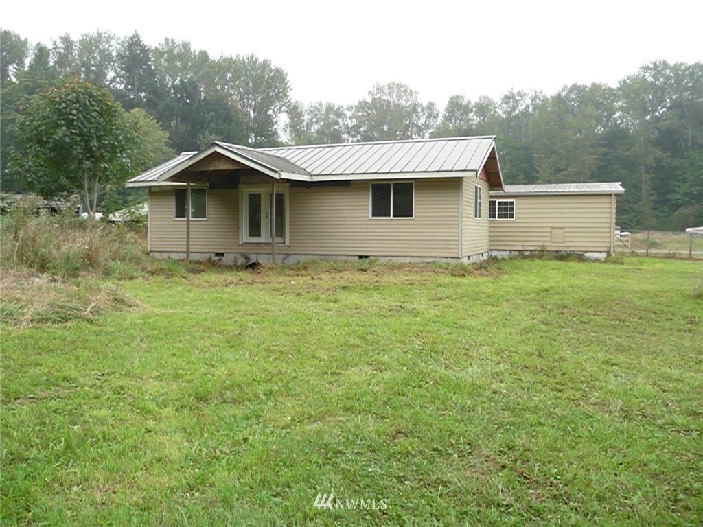 181 Head Gate Road Sequim, WA 98382 - Photo 4 of 18 a white house that has a tree in the grass