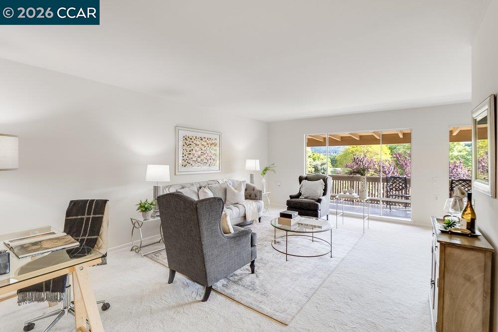 2801 Golden Rain Road, Unit 3 Walnut Creek, CA 94595 - Photo 6 of 29 a living room with furniture a flat screen tv and a floor to ceiling window