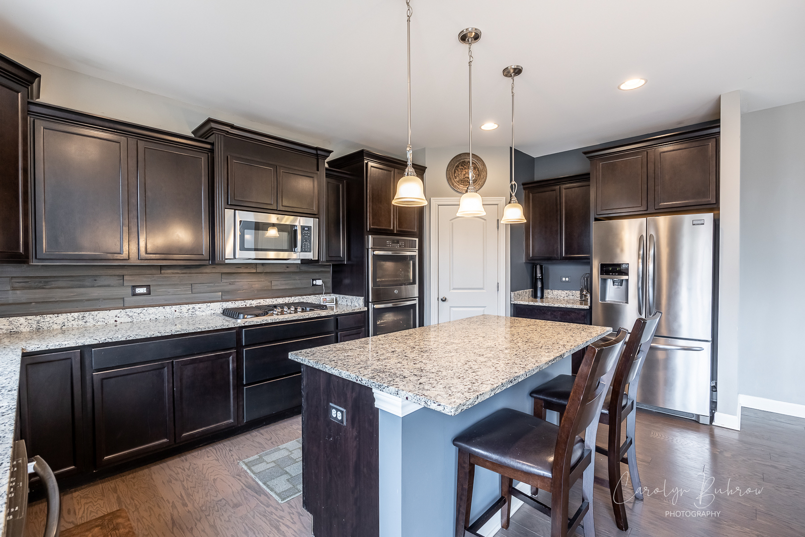 4354 Rudyard Kipling Road Elgin, IL 60124 - Photo 10 of 23 a kitchen with refrigerator a sink and chairs