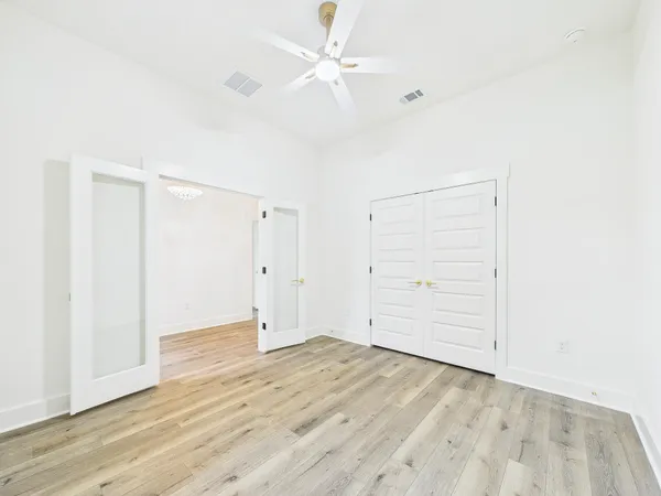 an empty room with a window and a ceiling fan