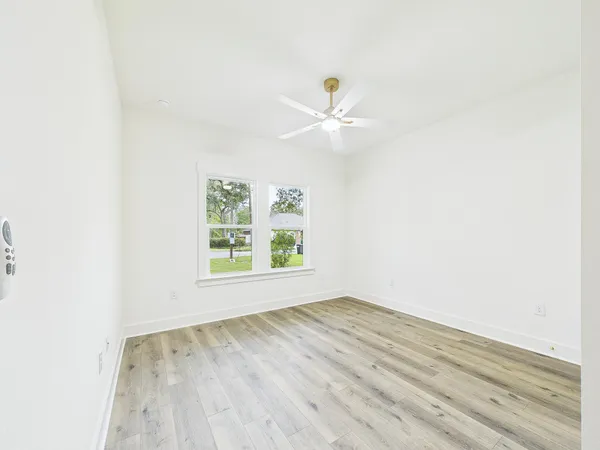 a view of an empty room with wooden floor