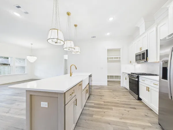 a kitchen with a sink dishwasher a stove top oven a counter space and cabinets