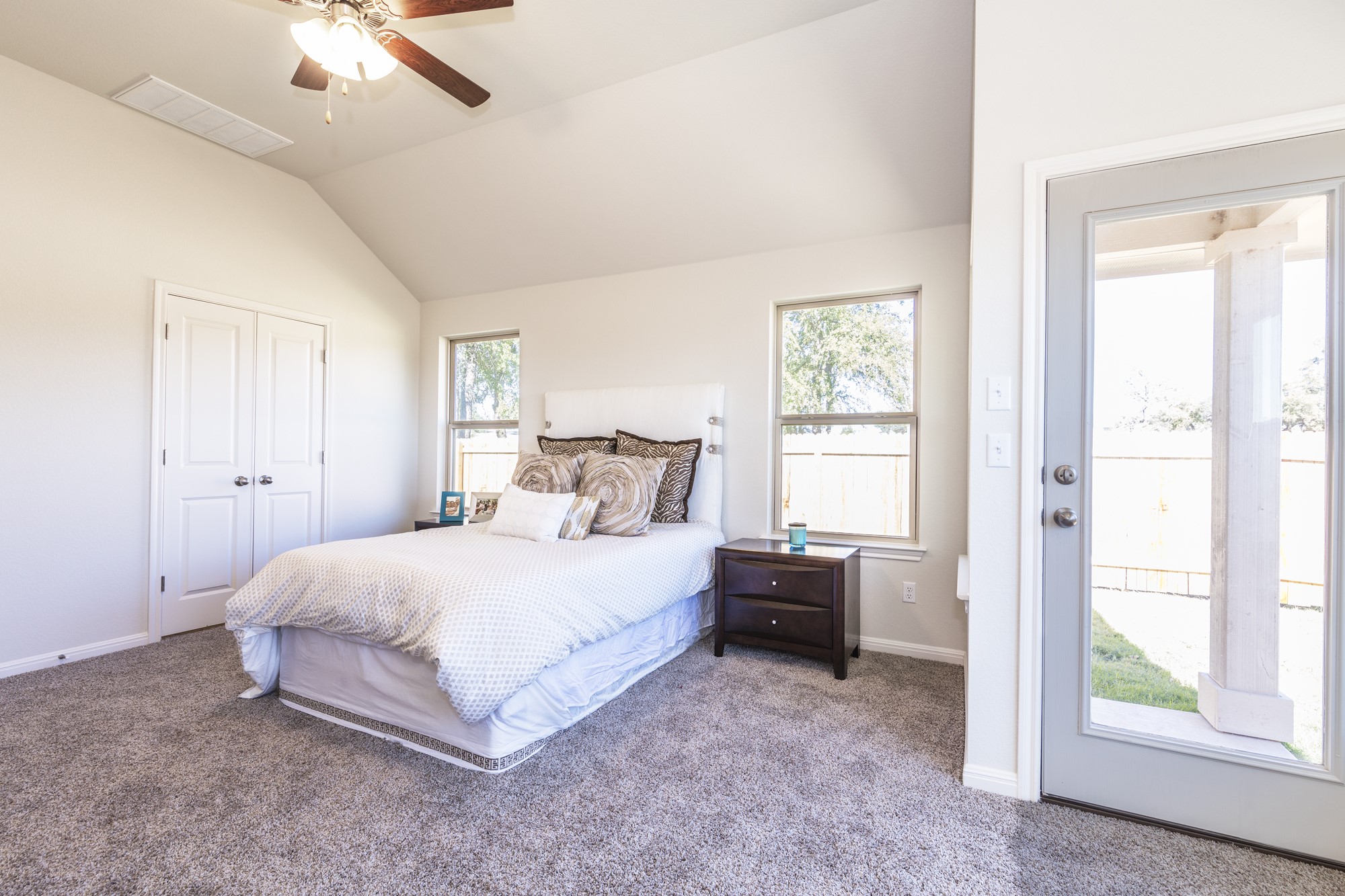 2725 Hopi Path Leander, TX 78641 - Photo 26 of 30 Natural light streams into this bedroom, featuring plush carpeting and a vaulted ceiling with a ceiling fan.