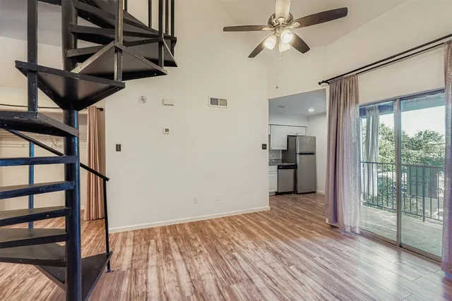 a view of hallway with wooden floor and chandelier