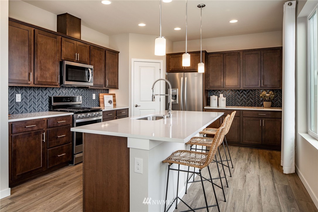118 215th Street Southeast, Unit 8 Bothell, WA 98021 - Photo 4 of 21 a kitchen with a sink a counter top space stainless steel appliances and cabinets