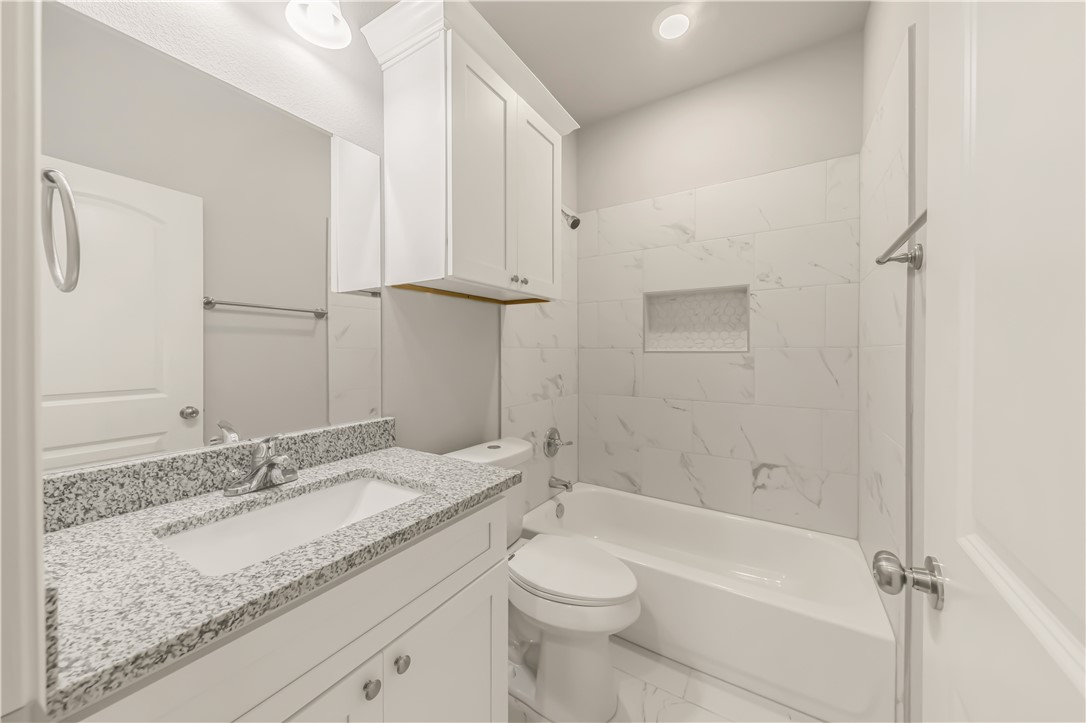 1801 Pin Oak Street Bryan, TX 77803 - Photo 11 of 17 a bathroom with a granite countertop sink toilet and shower