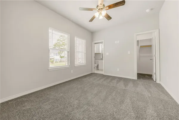 an empty room with windows and fan