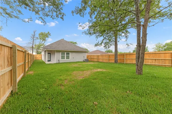 a view of an house with backyard and a tree
