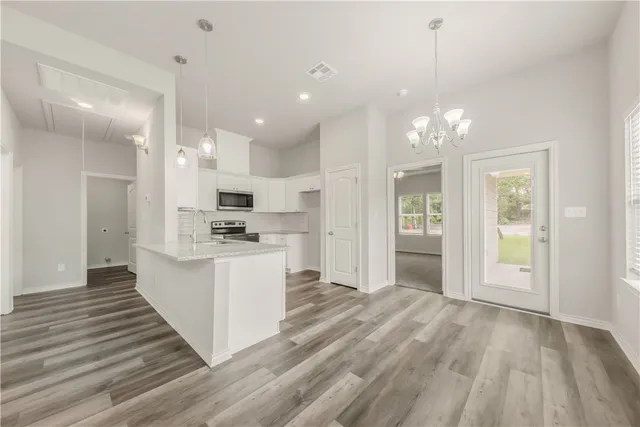 a large kitchen with kitchen island a sink stainless steel appliances and cabinets
