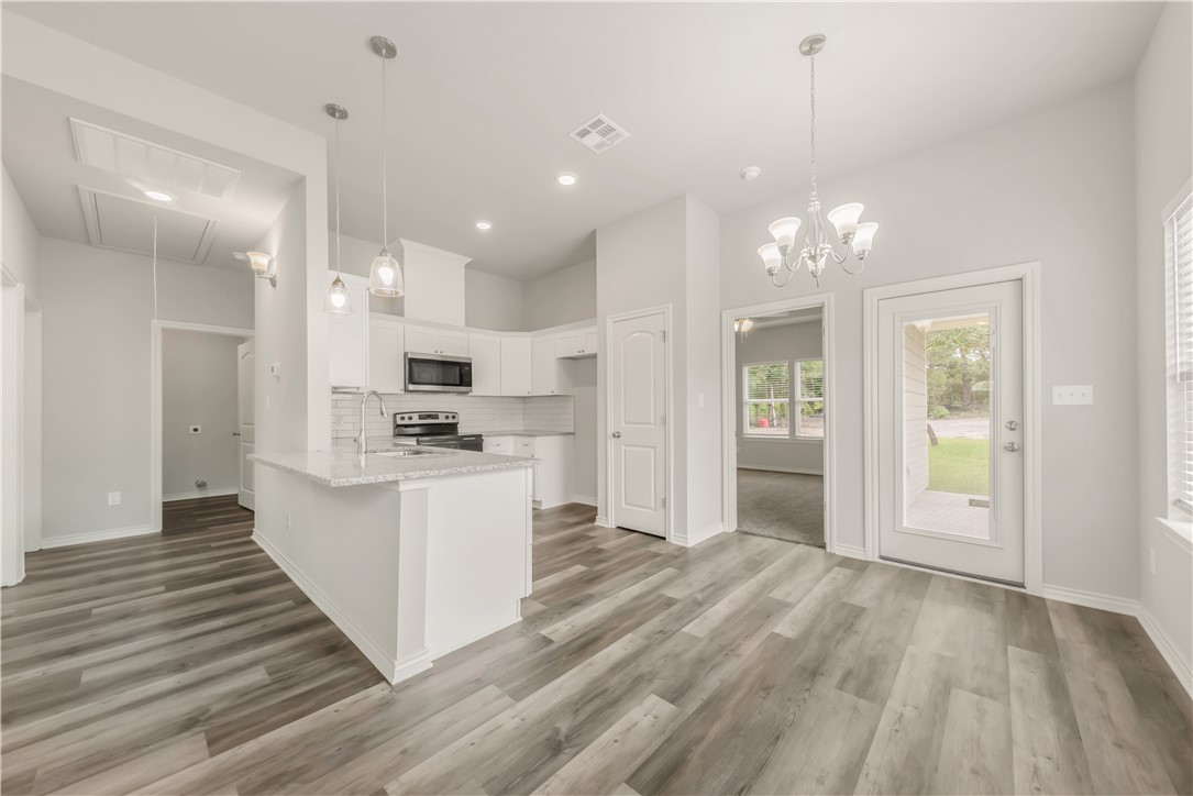 1801 Pin Oak Street Bryan, TX 77803 - Photo 3 of 17 a large kitchen with kitchen island a sink stainless steel appliances and cabinets