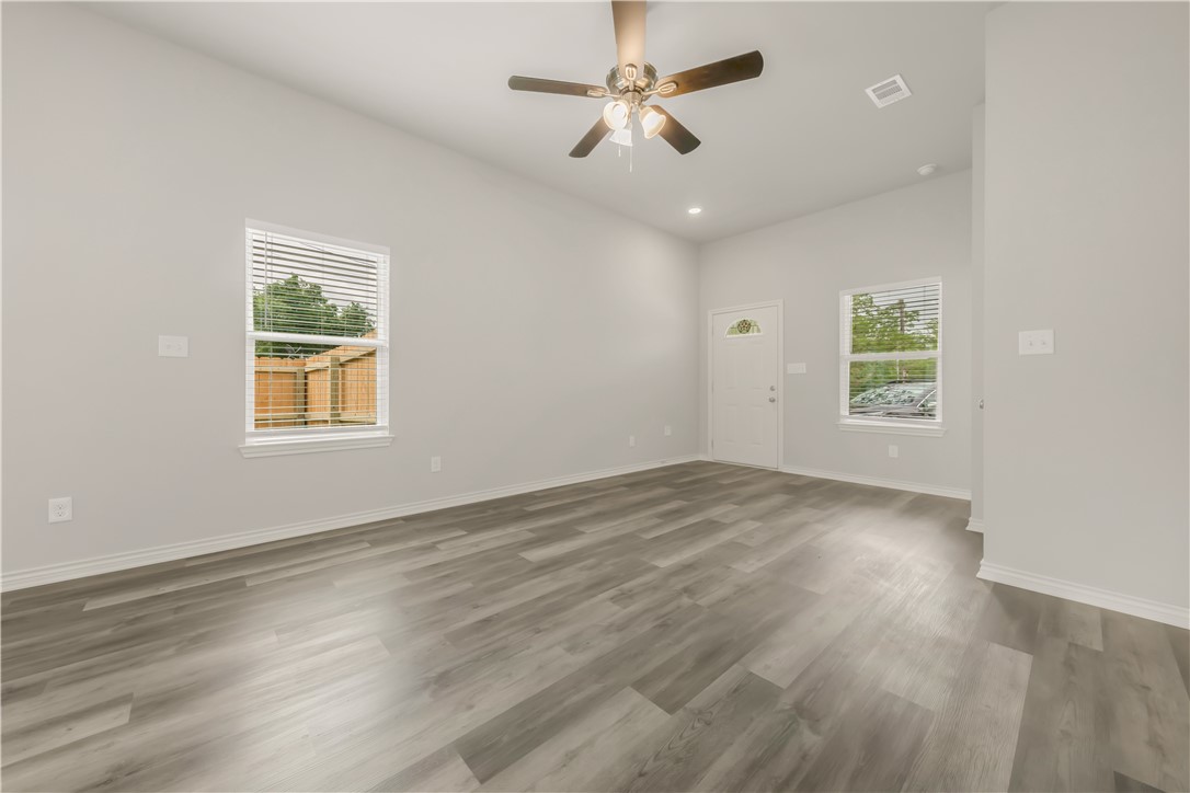 1801 Pin Oak Street Bryan, TX 77803 - Photo 5 of 17 a view of an empty room with a window and wooden floor