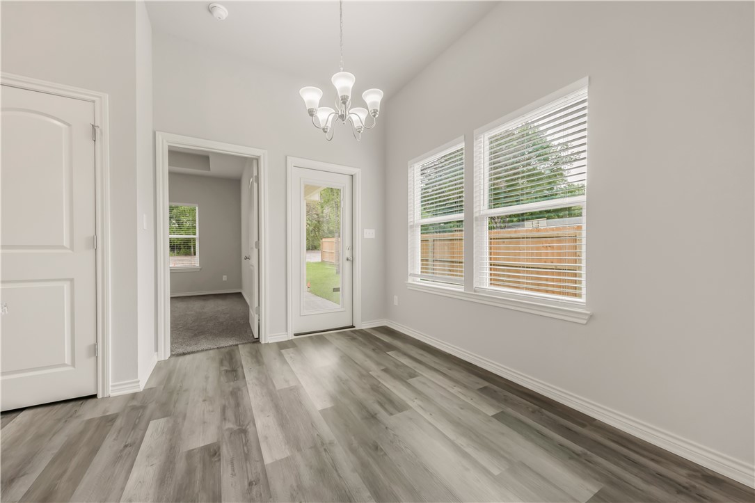 1801 Pin Oak Street Bryan, TX 77803 - Photo 6 of 17 wooden floor in an empty room with a window