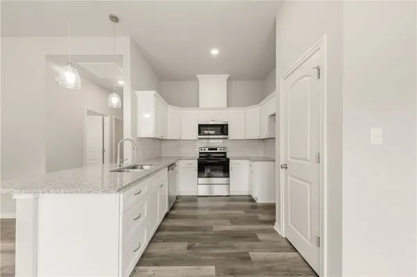 a large kitchen with a stove and a refrigerator