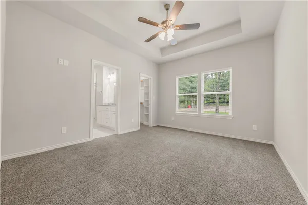 an empty room with windows and ceiling fan