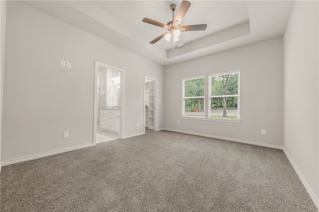 1801 Pin Oak Street Bryan, TX 77803 - Photo 9 of 17 an empty room with windows and ceiling fan