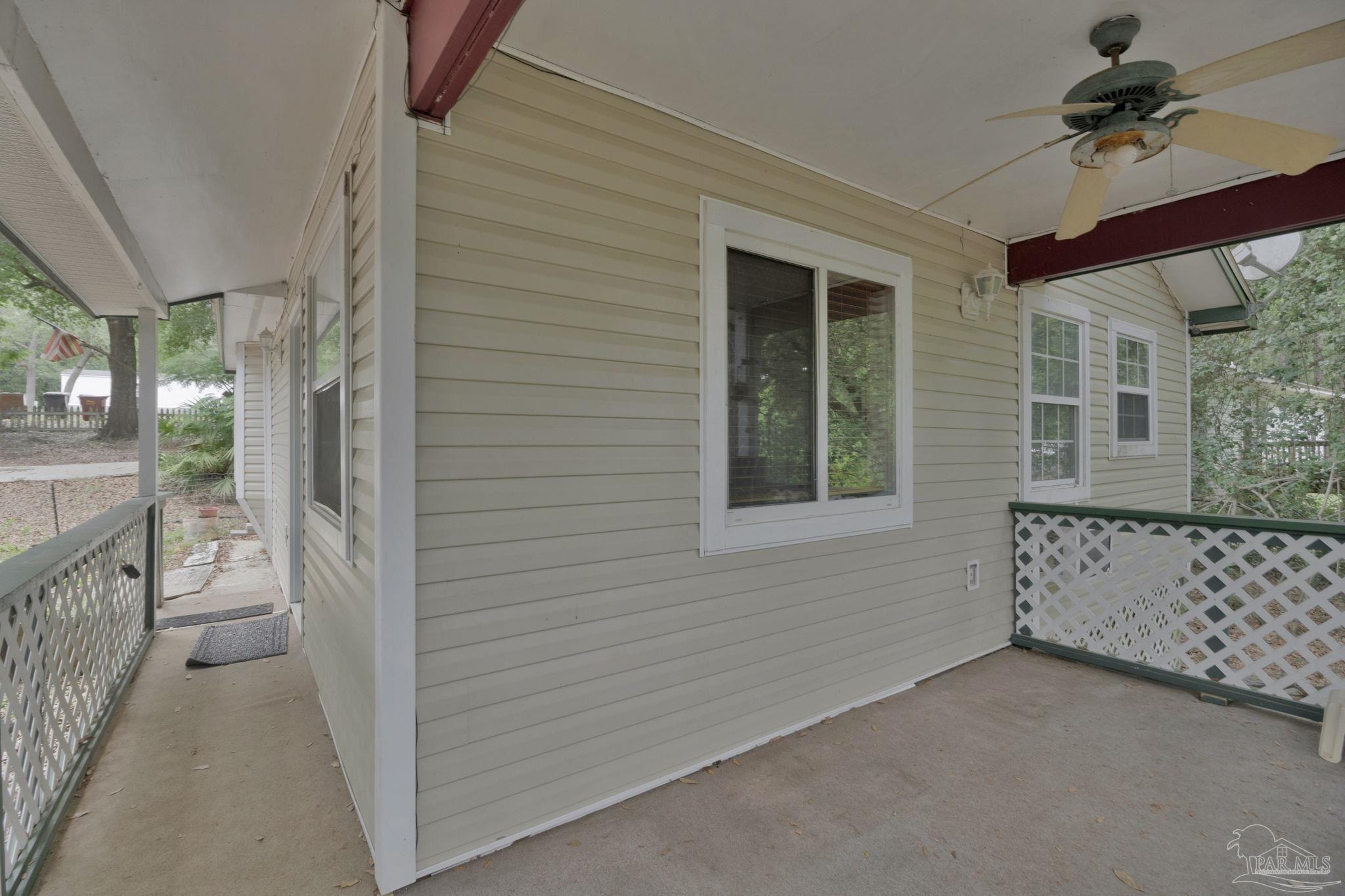 10290 West Lake Road Milton, FL 32583 - Photo 22 of 53 a view of a porch with wooden floor and front door