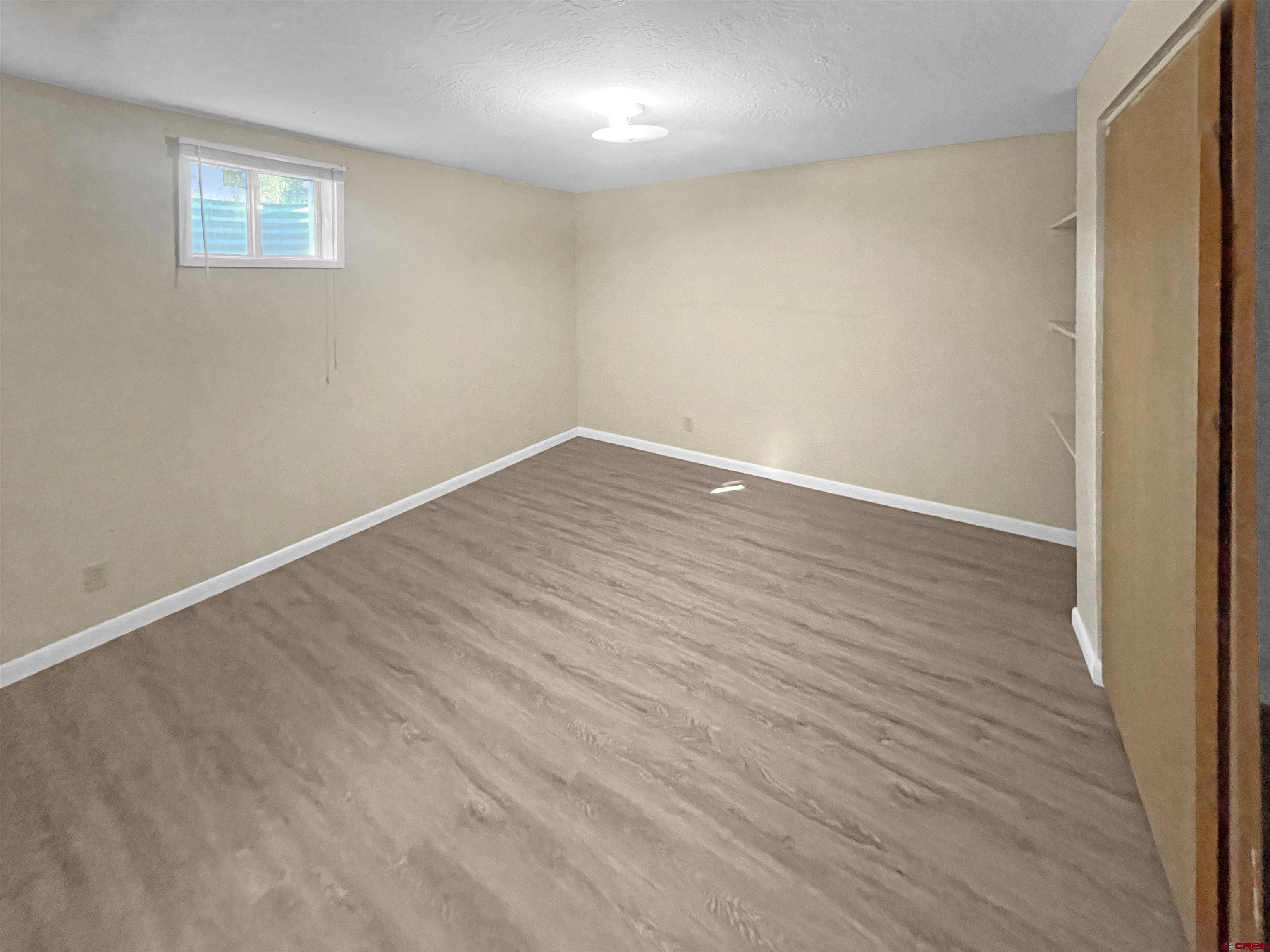 16 West 10th Street Cortez, CO 81321 - Photo 13 of 18 a view of an empty room with wooden floor and a window