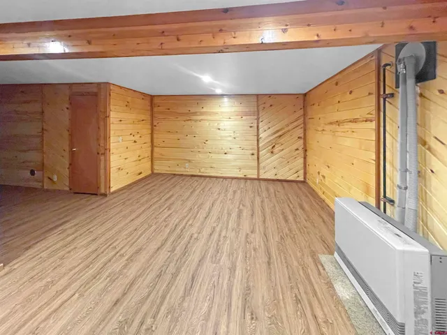 a view of a big room with wooden floor and windows