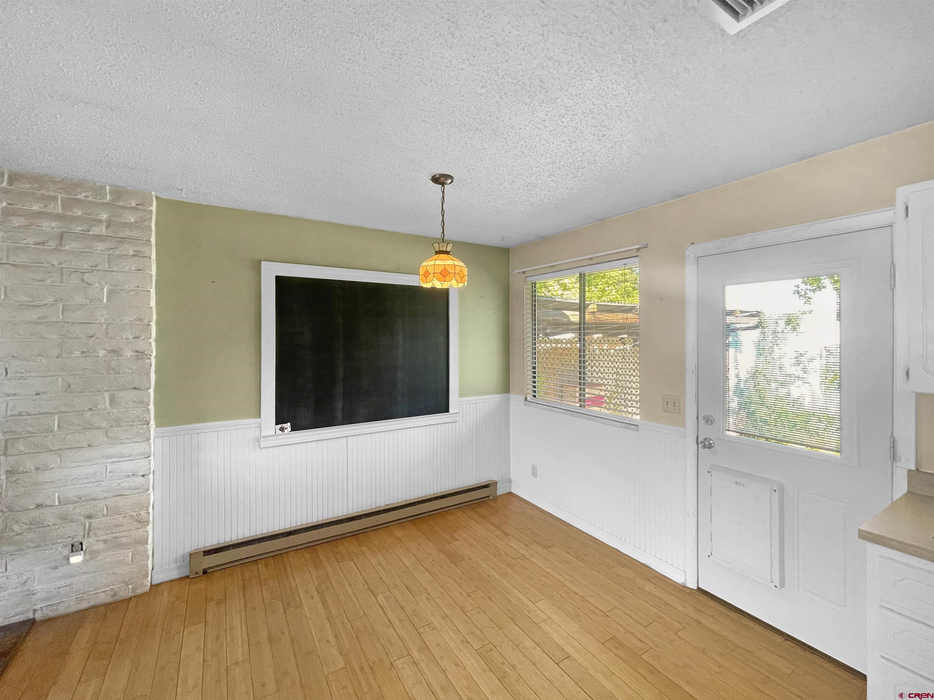 16 West 10th Street Cortez, CO 81321 - Photo 5 of 18 an empty room with wooden floor and windows
