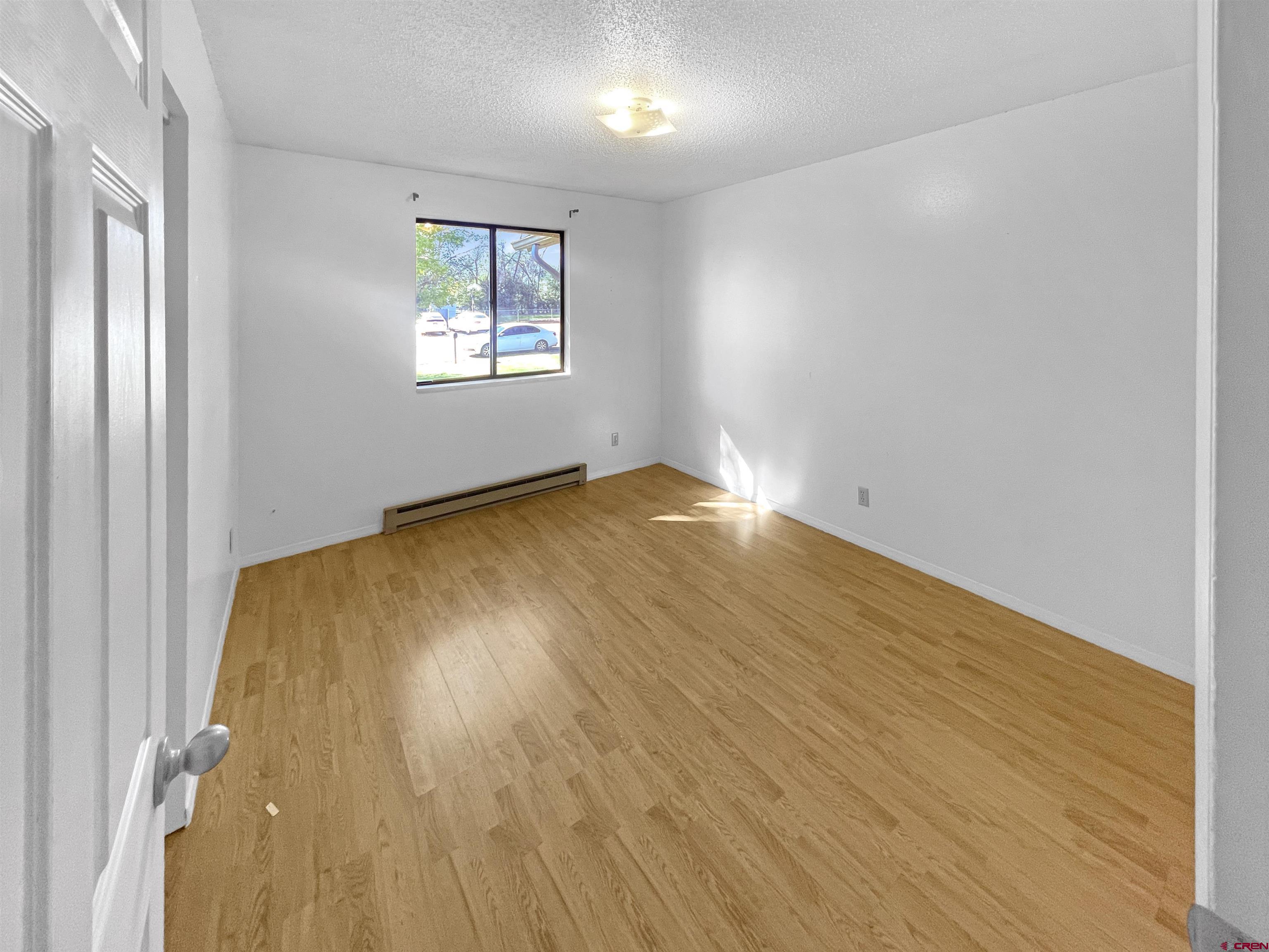 16 West 10th Street Cortez, CO 81321 - Photo 9 of 18 wooden floor in an empty room with a window