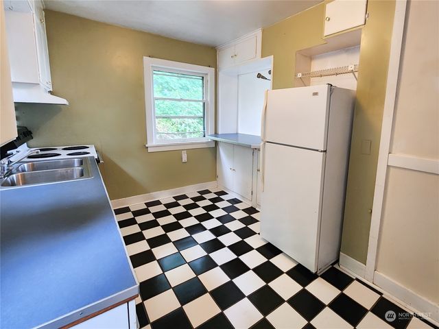 a kitchen with a refrigerator and a stove top oven