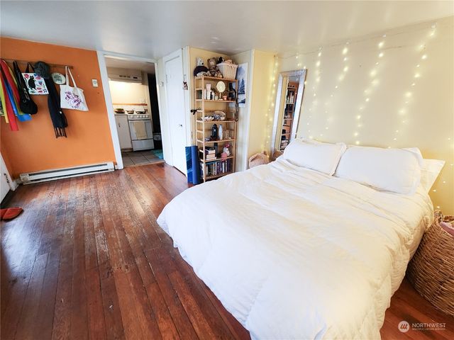 a spacious bedroom with a bed and a wooden floor