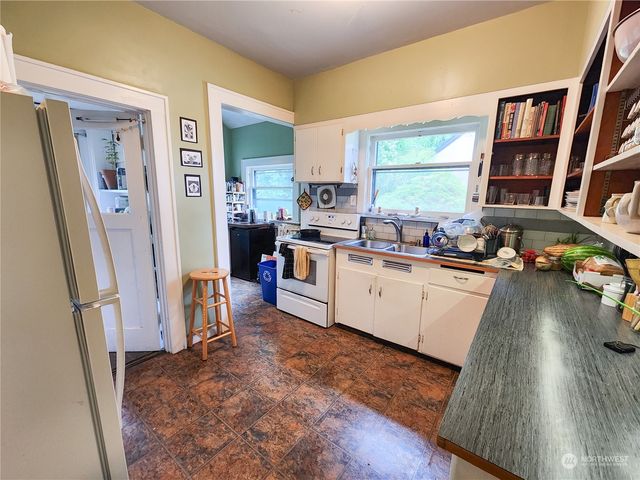 a kitchen with stainless steel appliances a refrigerator a sink a stove and cabinets