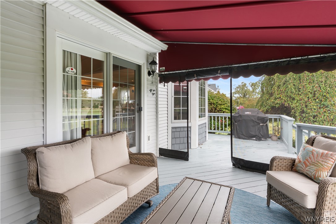 2850 Amsdell Road, Unit 34 Hamburg, NY 14075 - Photo 29 of 33 A spacious wooden deck under a retractable awning provides the perfect setting for outdoor relaxation.