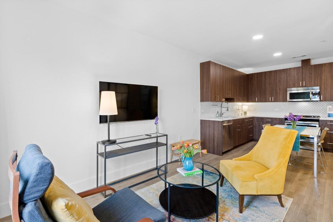 2213 Poquito Street, Unit 319 Austin, TX 78722 - Photo 13 of 22 a living room with furniture and a flat screen tv