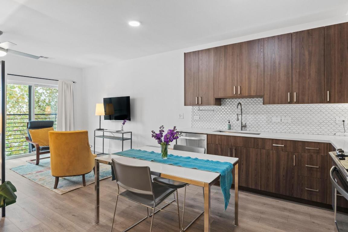 2213 Poquito Street, Unit 319 Austin, TX 78722 - Photo 4 of 22 a kitchen with a cabinets appliances and a dining table
