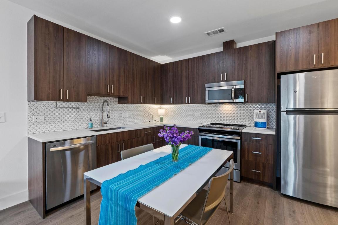 2213 Poquito Street, Unit 319 Austin, TX 78722 - Photo 7 of 22 a kitchen with a stove a refrigerator and a sink