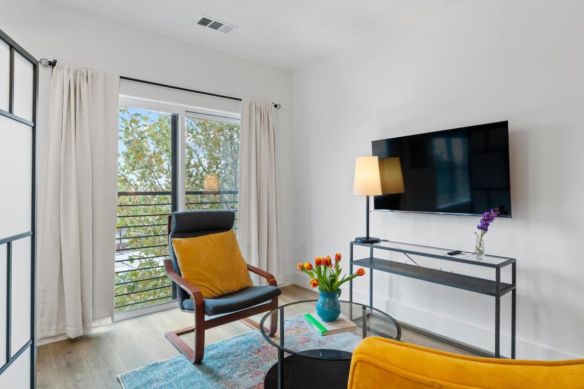 2213 Poquito Street, Unit 319 Austin, TX 78722 - Photo 8 of 22 a living room with furniture and a flat screen tv