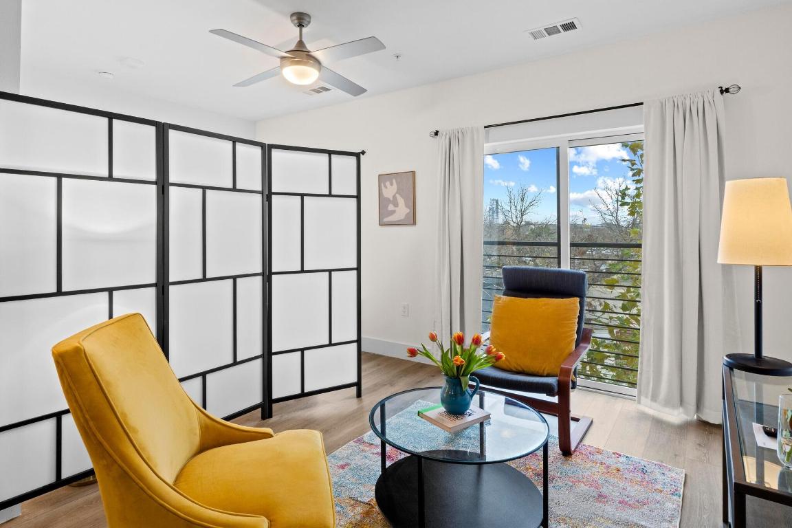 2213 Poquito Street, Unit 319 Austin, TX 78722 - Photo 10 of 22 a living room with furniture a flat screen tv and a large window