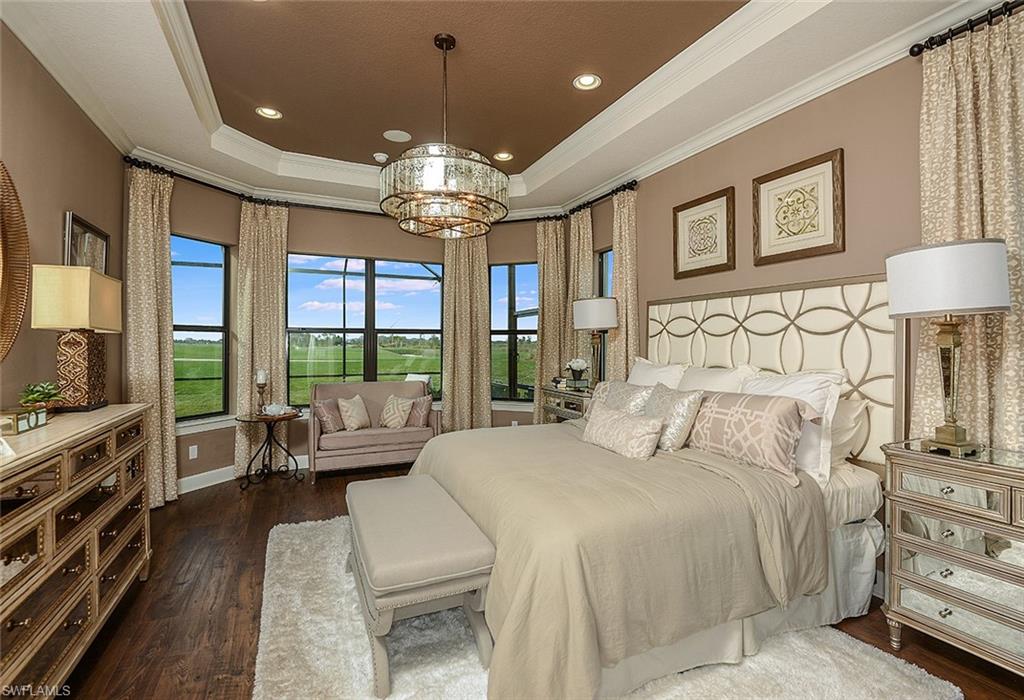 8558 Maggiore Court Naples, FL 34114 - Photo 13 of 32 a bedroom with a large bed and a chandelier