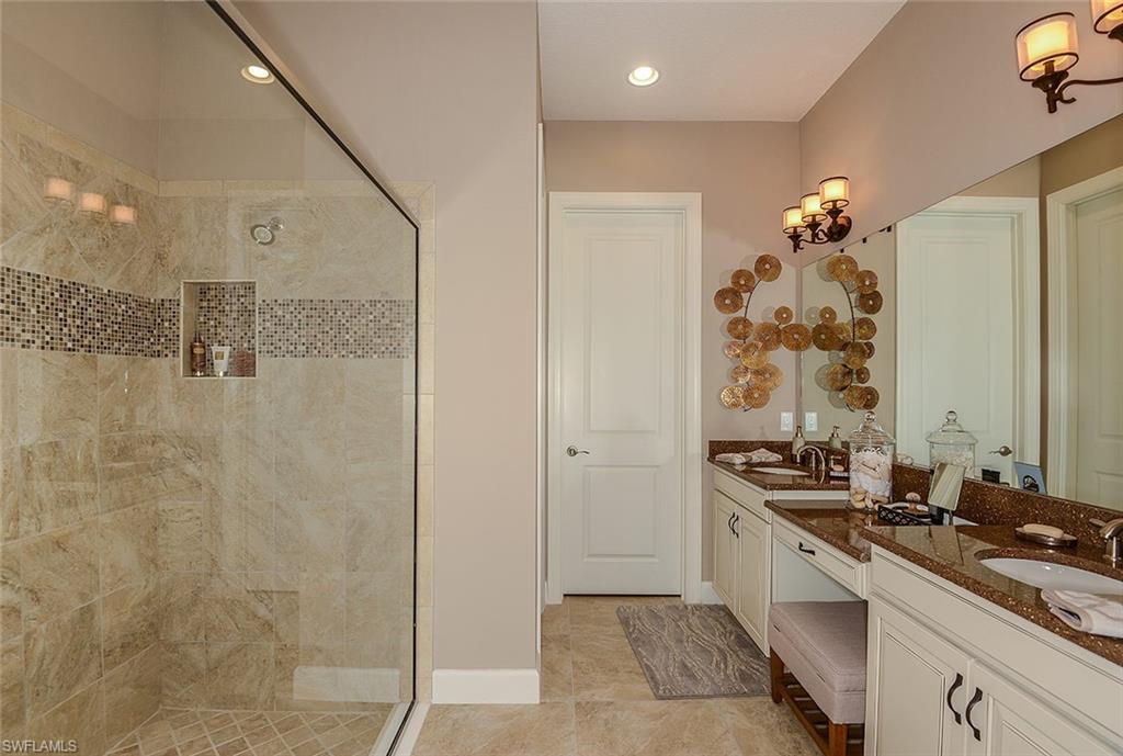 8558 Maggiore Court Naples, FL 34114 - Photo 15 of 32 a bathroom with a double vanity sink a mirror and a shower