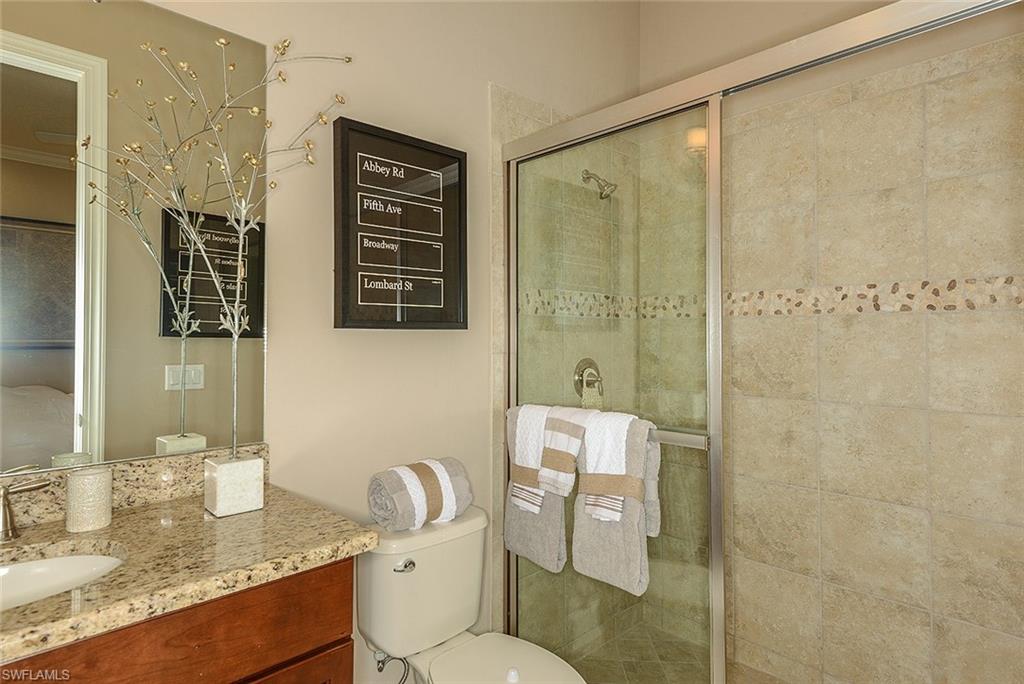 8558 Maggiore Court Naples, FL 34114 - Photo 17 of 32 a bathroom with a granite countertop sink toilet and shower