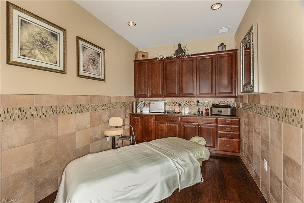 8558 Maggiore Court Naples, FL 34114 - Photo 29 of 32 a bedroom with a bed and cabinets
