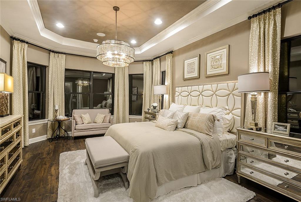 8558 Maggiore Court Naples, FL 34114 - Photo 3 of 32 a bedroom with a large bed and a chandelier