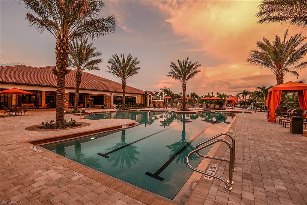 8558 Maggiore Court Naples, FL 34114 - Photo 31 of 32 a view of a swimming pool with a lounge chair and palm trees