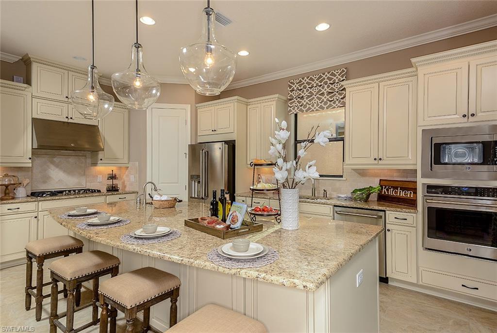 8558 Maggiore Court Naples, FL 34114 - Photo 10 of 32 a kitchen with kitchen island granite countertop a sink cabinets and stainless steel appliances