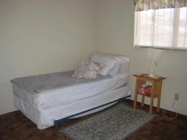 a bed sitting in a bedroom next to a window