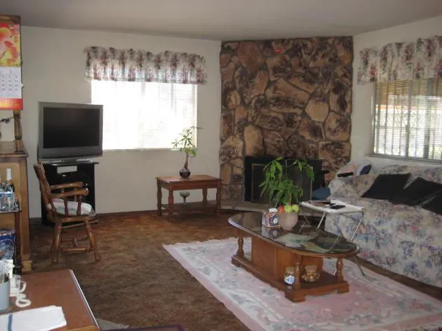 a living room with furniture a flat screen tv and a large window